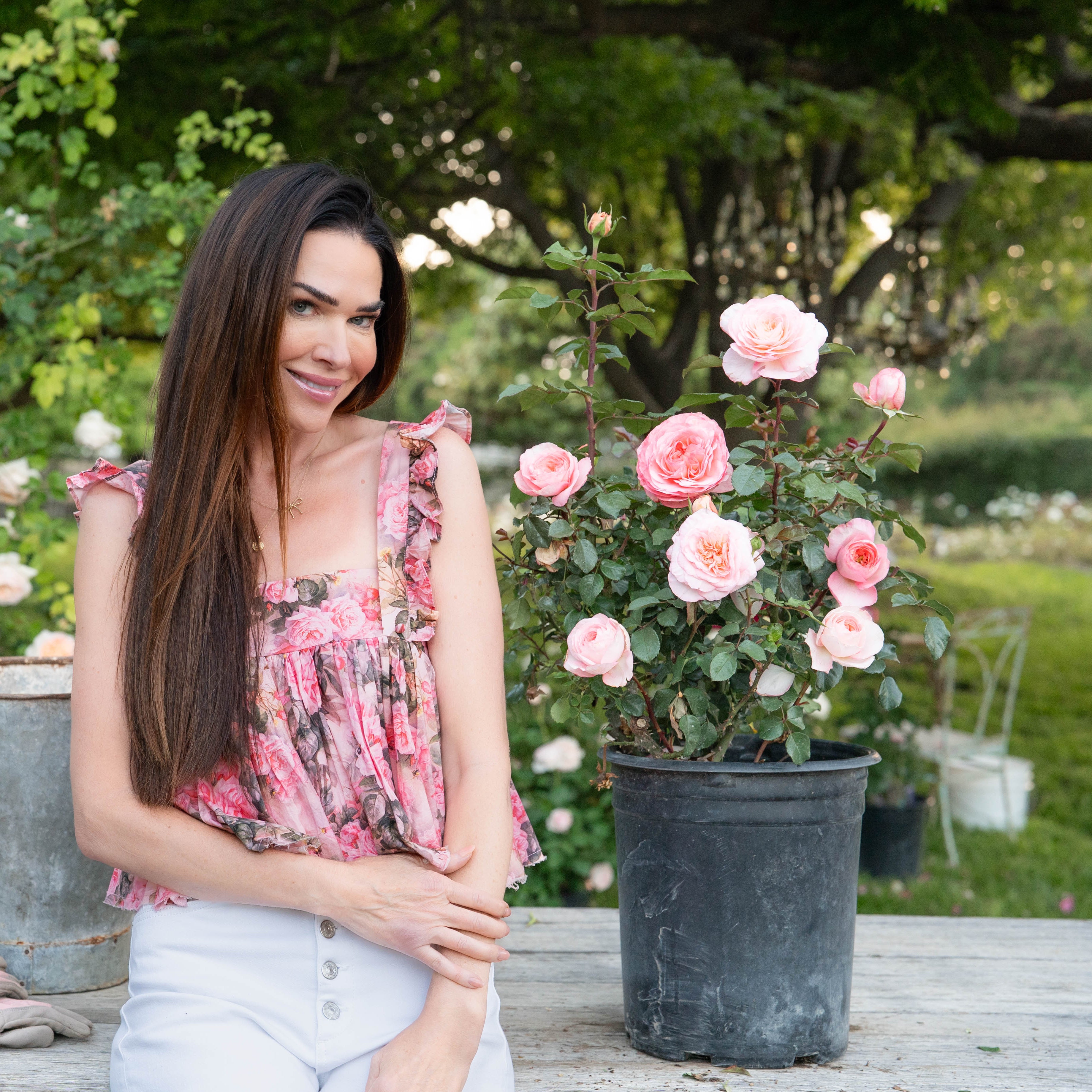 Woman standing in a garden with flowers and plants around her