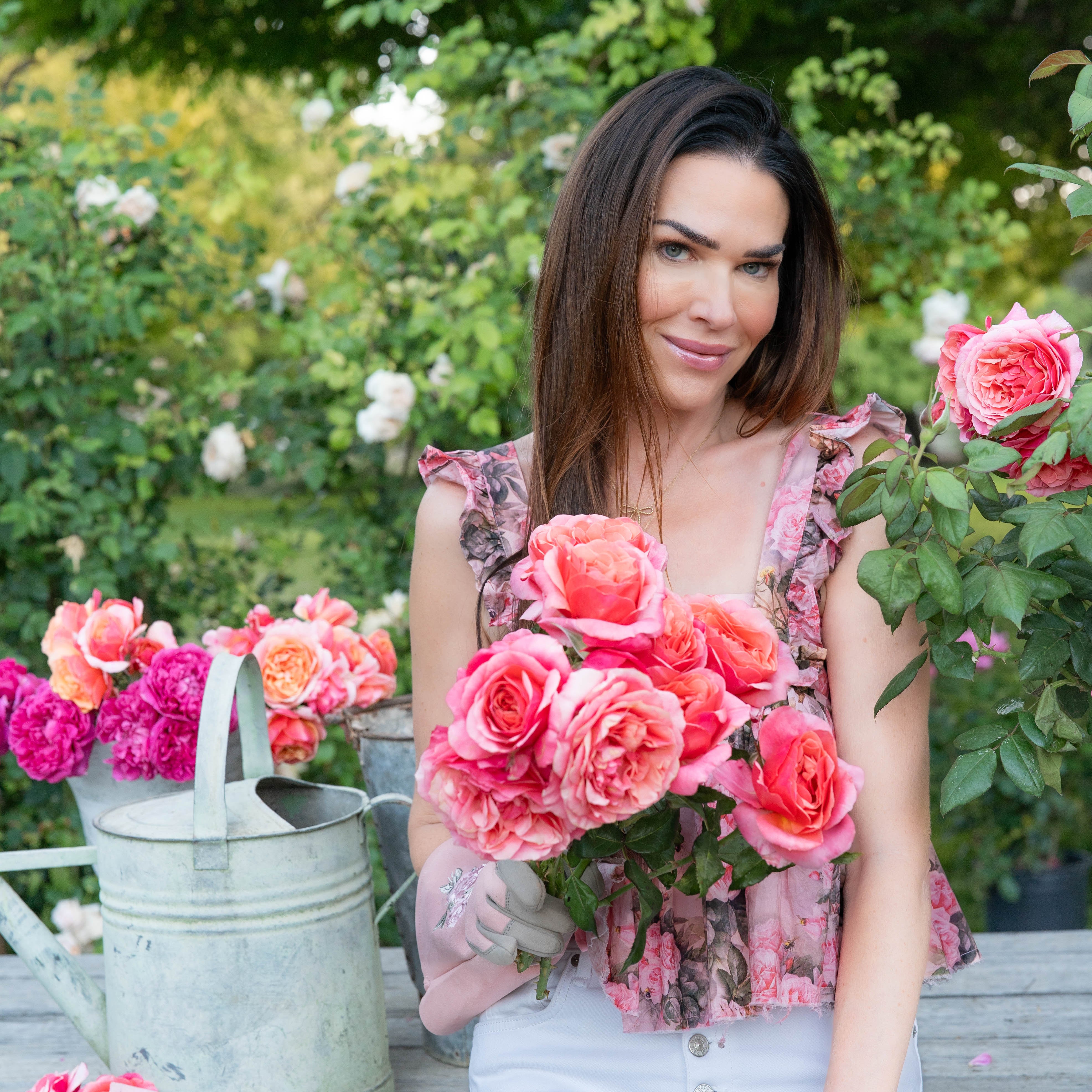 Woman holding a bouquet of pink flowers in a garden setting