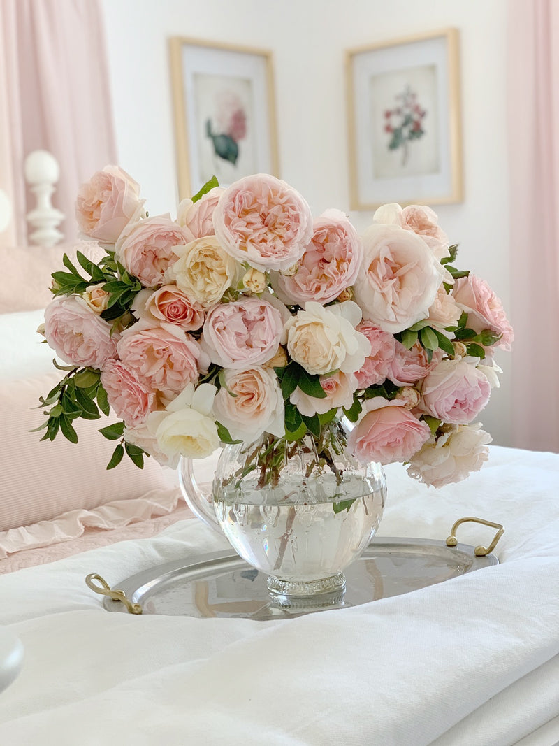 rose bouquet in clear vase on bed
